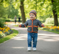 gemknits4kids hand-knitted charcoal and orange striped baby cardigan and matching beanie hat worn by a toddler