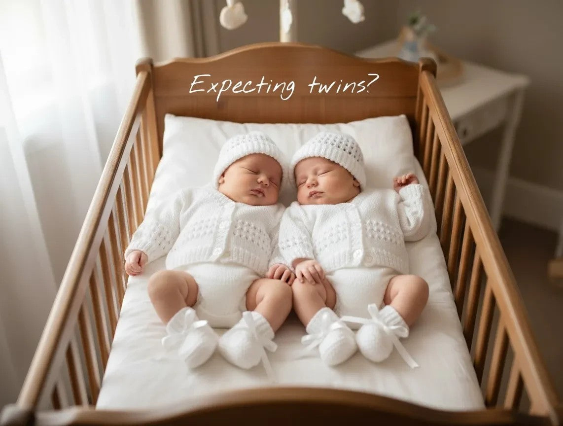 gemknits4kids hand-knitted white 4-piece baby coming home outfits on newborn twins in a wooden crib