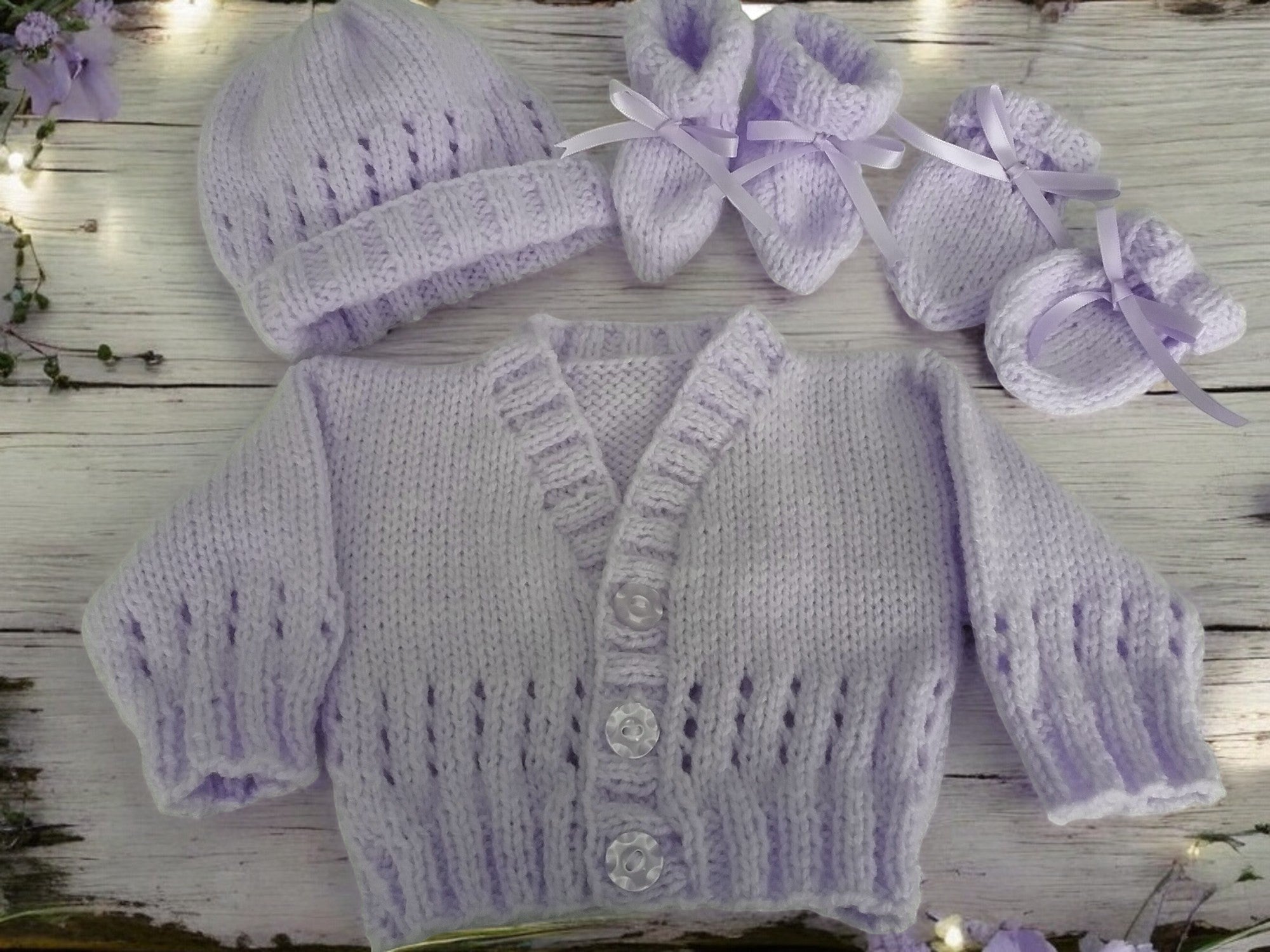 gemknits4kids baby wearing a soft lilac hand-knitted cardigan, hat, and booties