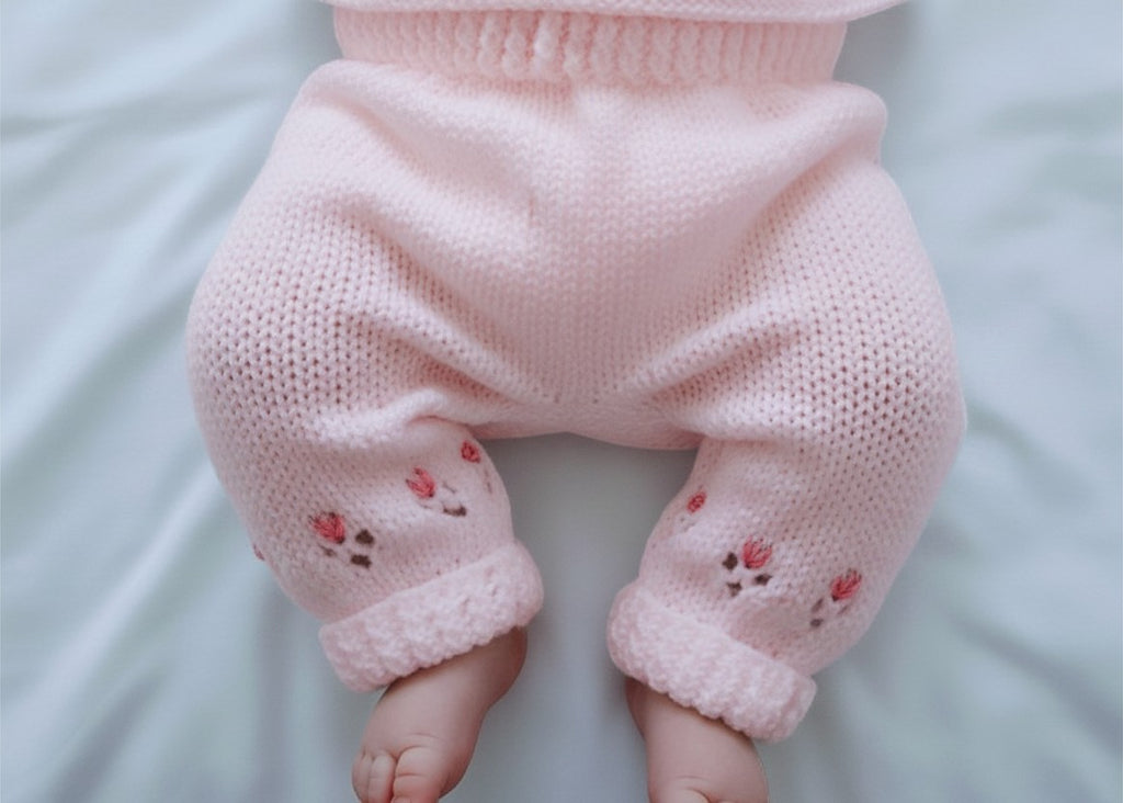 gemknits4kids hand knitted baby leggings in soft pink acrylic yarn with delicate floral embroidery on the cuffs
