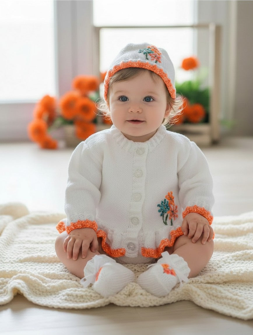 gemknits4kids white hand-knitted baby cardigan with orange floral embroidery, matching hat, and booties on a baby