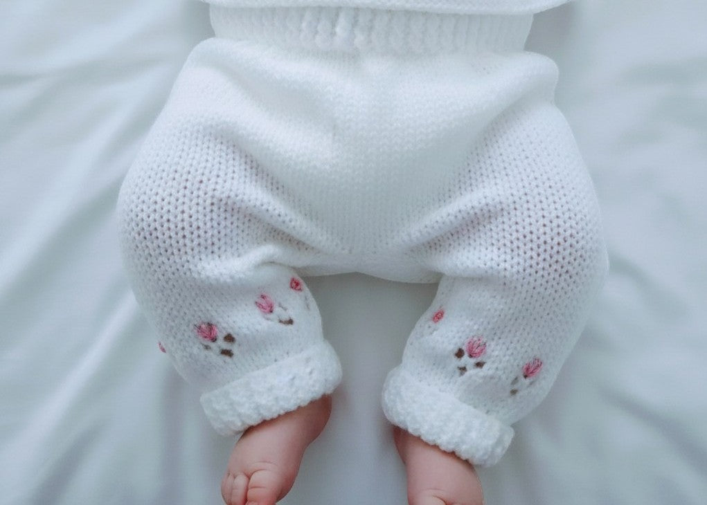 gemknits4kids white hand knitted baby leggings with delicate pink floral embroidery on soft acrylic yarn
